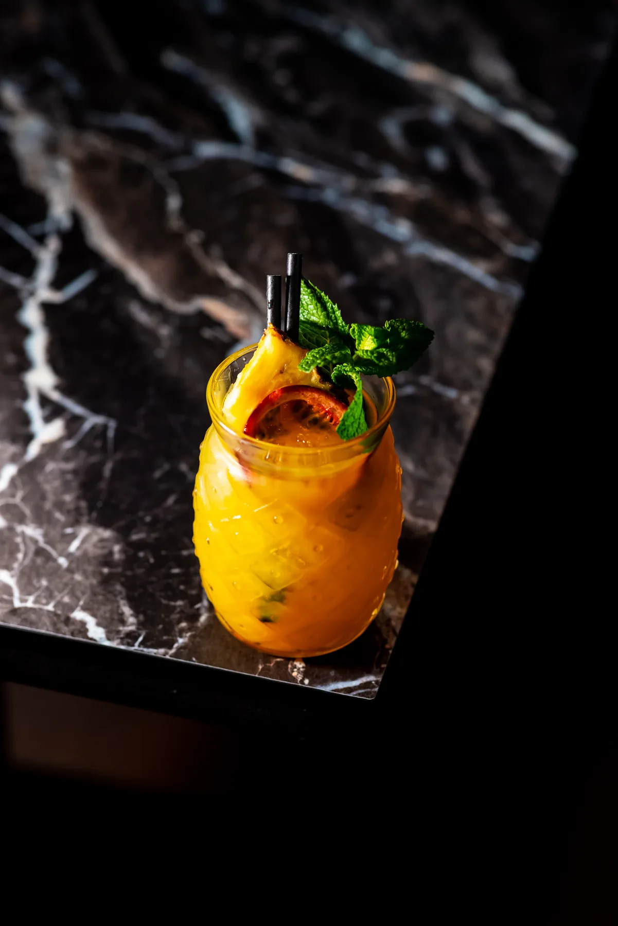 Orange cocktail on dark bar surface